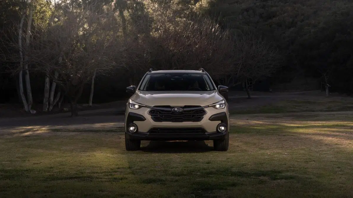 Vista frontal del Subaru Crosstrek Hybrid 2025 en un camino de tierra, rodeado de paisajes naturales.