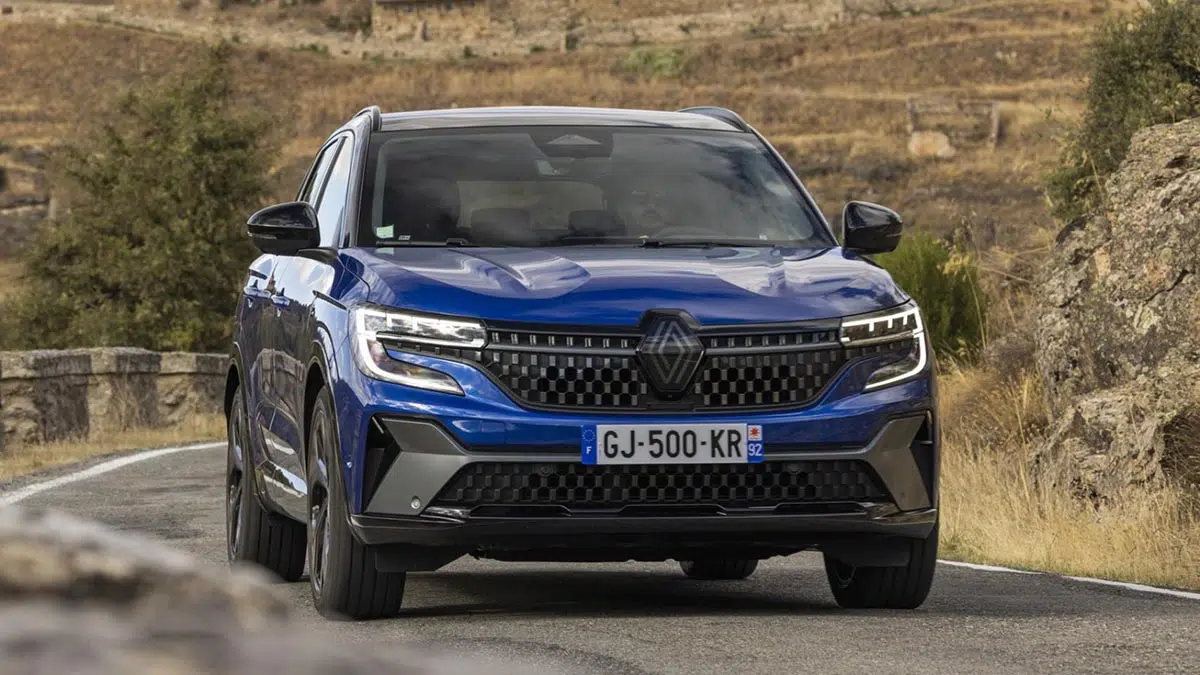 Renault Austral híbrido E-Tech en movimiento en una carretera rural, mostrando su diseño aerodinámico