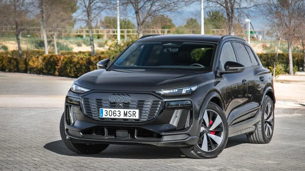 Vista frontal del Audi Q6 e-tron quattro en movimiento, mostrando su parrilla cerrada característica y sus líneas aerodinámicas.