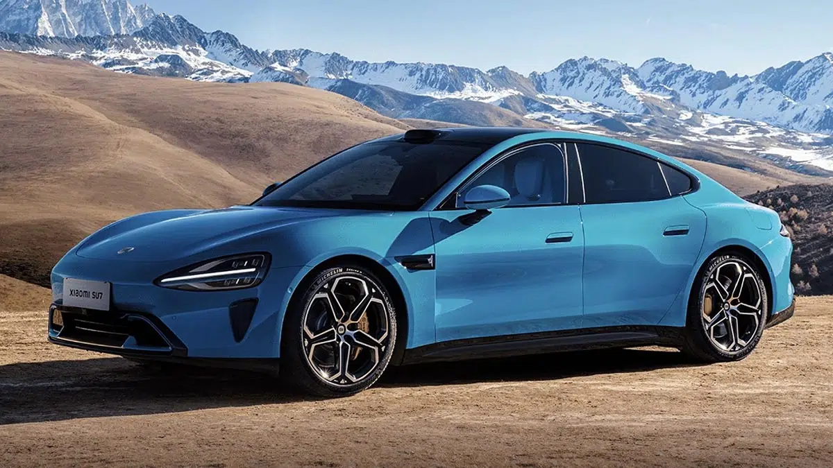 Xiaomi SU7, coche eléctrico futurista en una carretera urbana de China, destacando su diseño aerodinámico y rendimiento superior al Tesla Model 3.