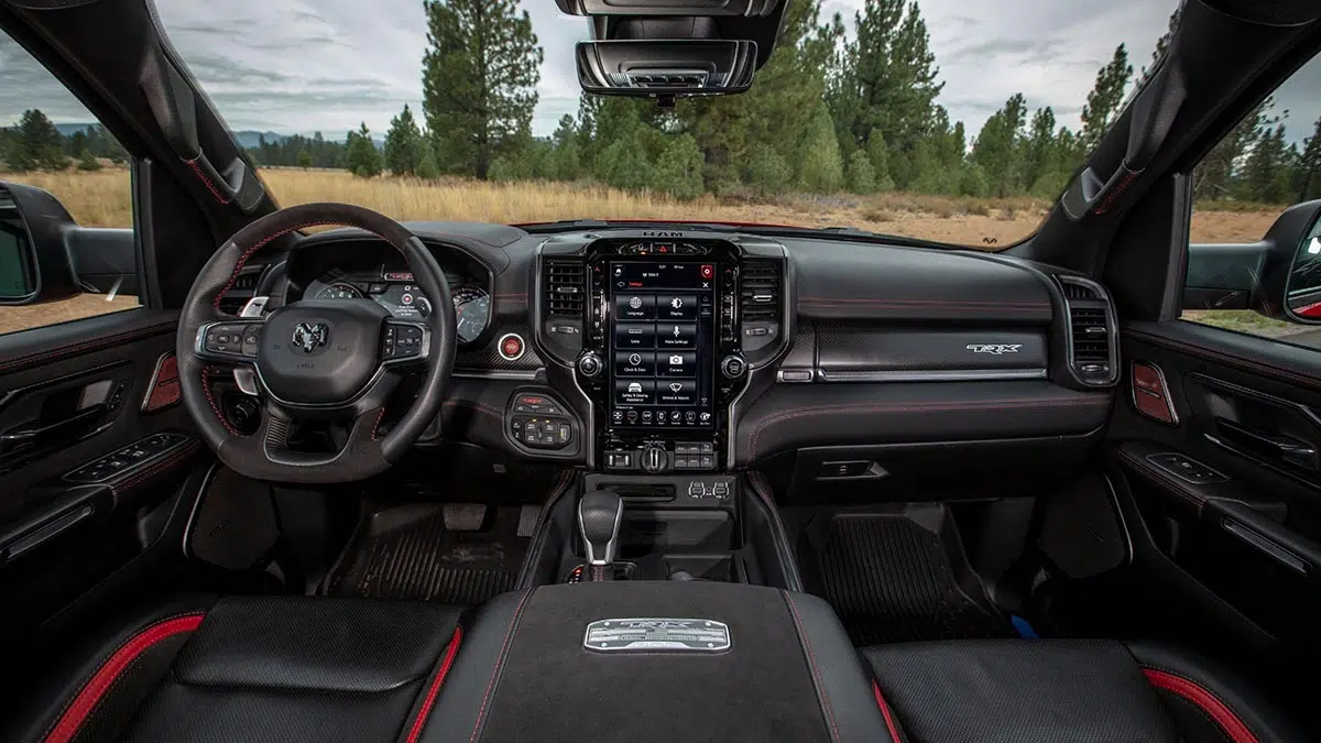 Vista interior del Ram 1500 TRX 2025, ilustrando su pantalla táctil gigante y sus acabados premium.