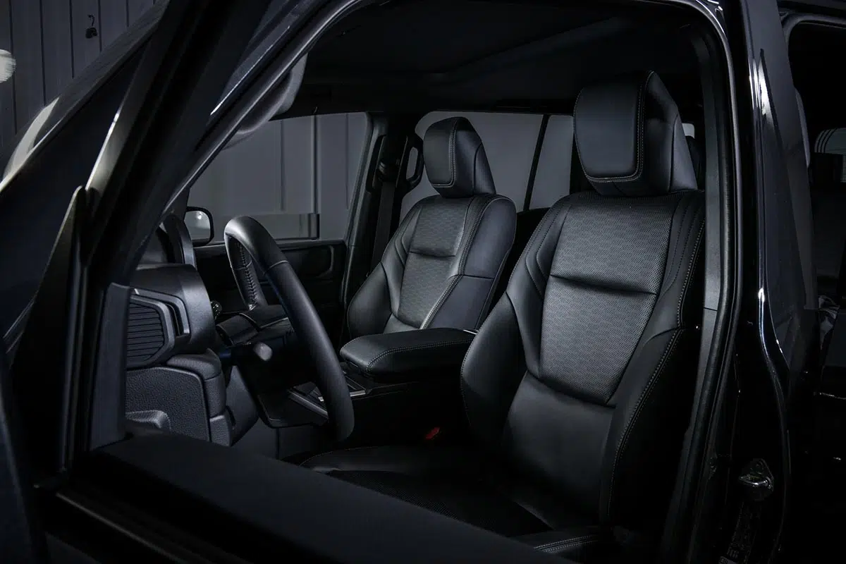 Interior del Toyota Land Cruiser AT37 con acabado sobrio y controles todoterreno