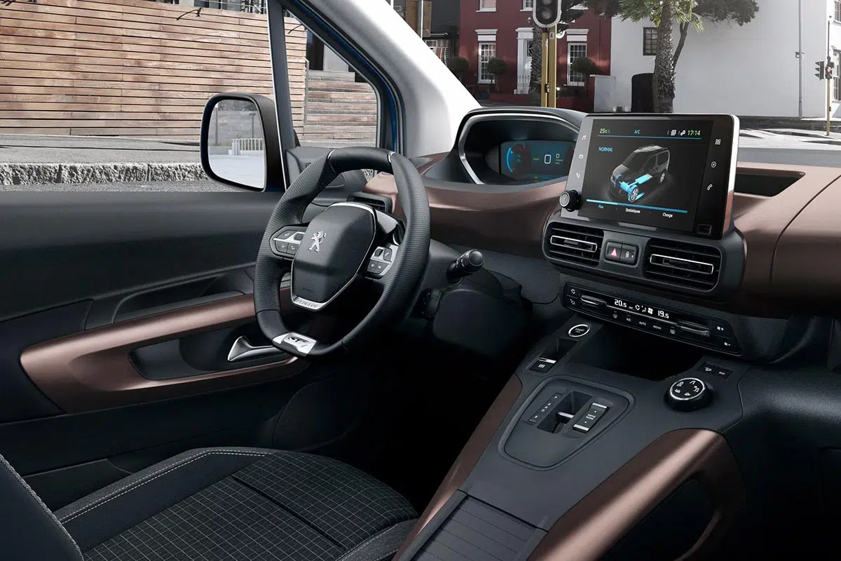 Intérieur de la Peugeot e-Rifter, montrant le tableau de bord avec l'écran tactile central et les commandes ergonomiques