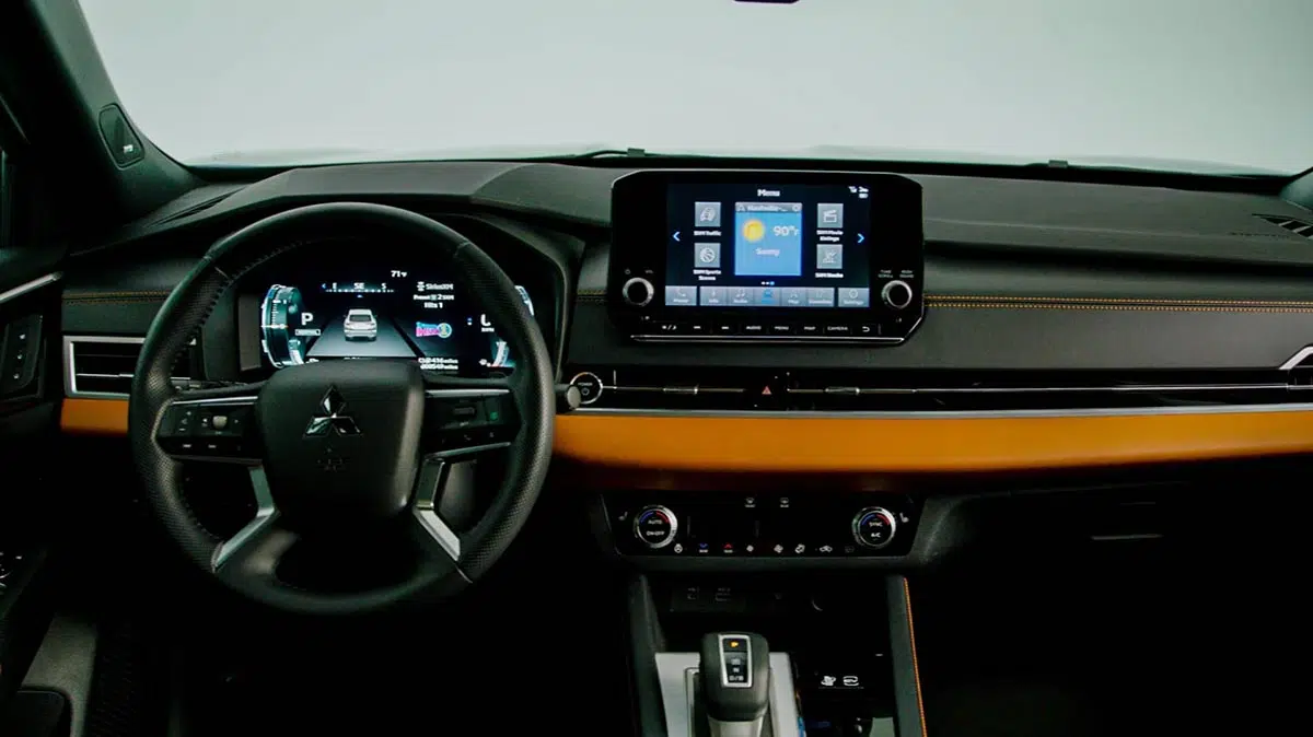 Interior del Mitsubishi Outlander PHEV 2025 con pantalla táctil de 8 pulgadas y volante multifunción
