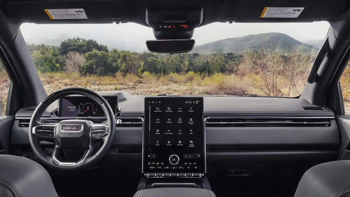 Interior del GMC Sierra EV AT4 2026 con volante multifuncional y pantalla táctil central