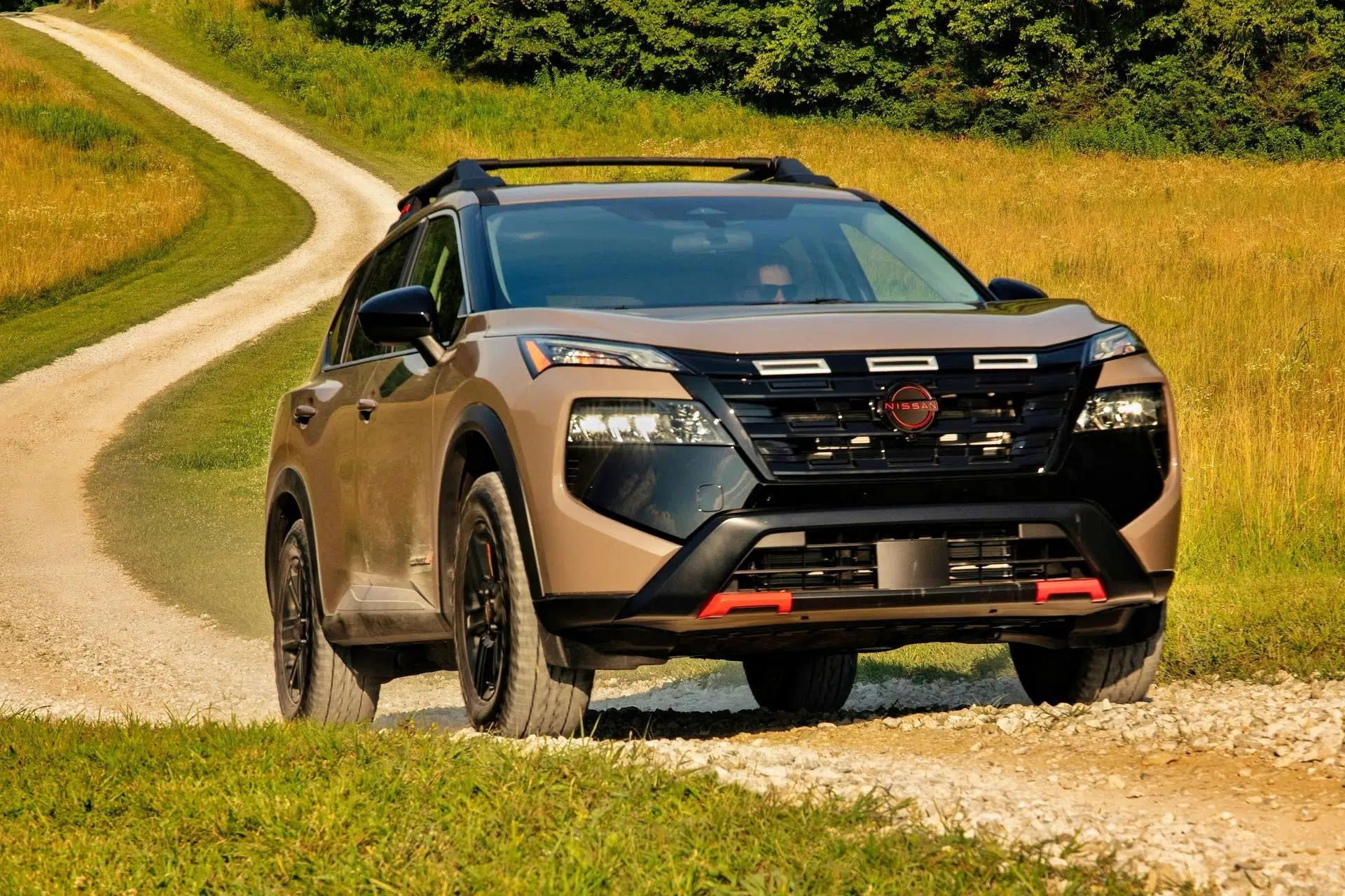 Frente del Nissan Rogue Rock Creek 2025 con parrilla negra y acentos Lava Red