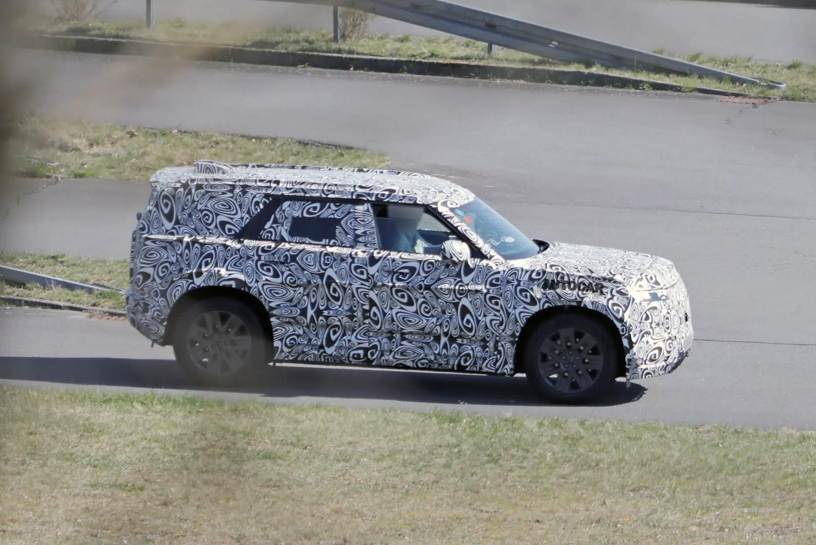 Prototipo Baby Defender Land Rover en pruebas en carretera, completamente camuflado sobre un SUV compacto