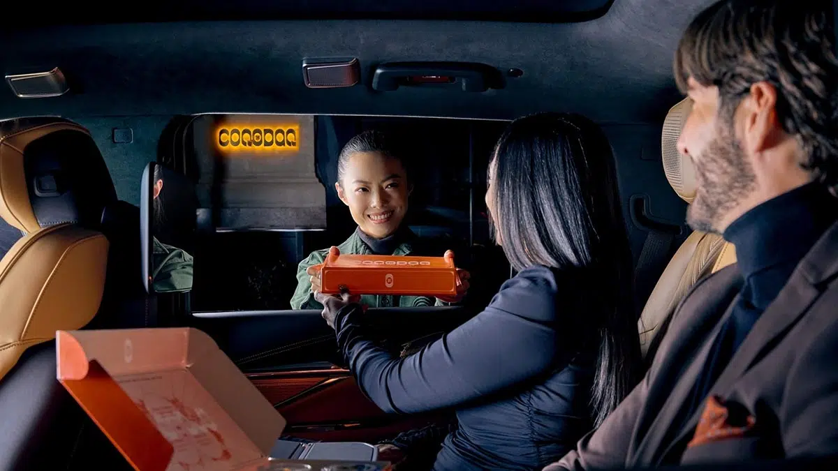 Comida gourmet servida dentro del Cadillac Escalade IQ sobre tabletas desplegadas
