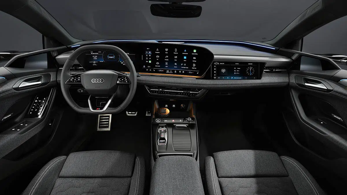 Interior del Audi A6 e-tron con pantalla digital curva doble y volante multifuncional.