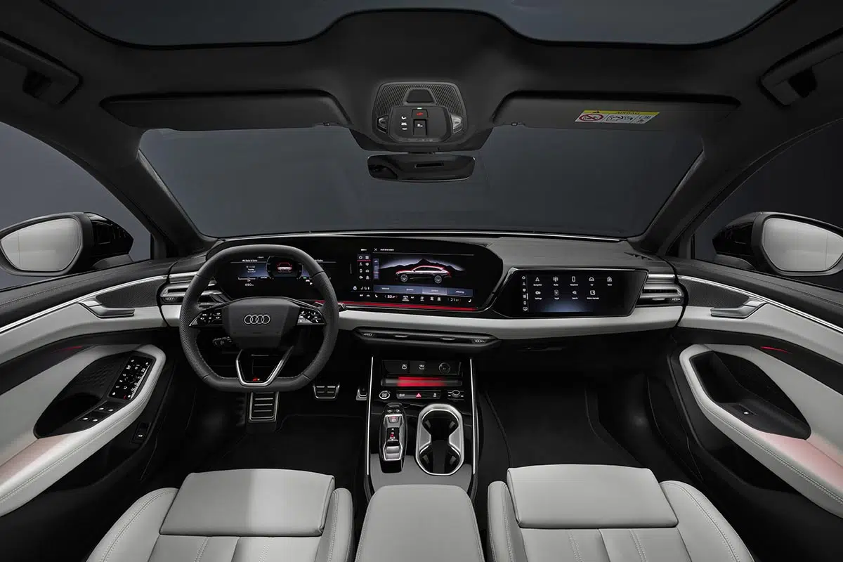 Interior del Audi A6 Berlina con triple pantalla digital y acabados en cuero y aluminio.
