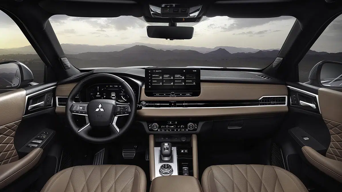 Interior del Mitsubishi Outlander PHEV con doble pantalla digital, acabados de cuero y cabeza de visualización.