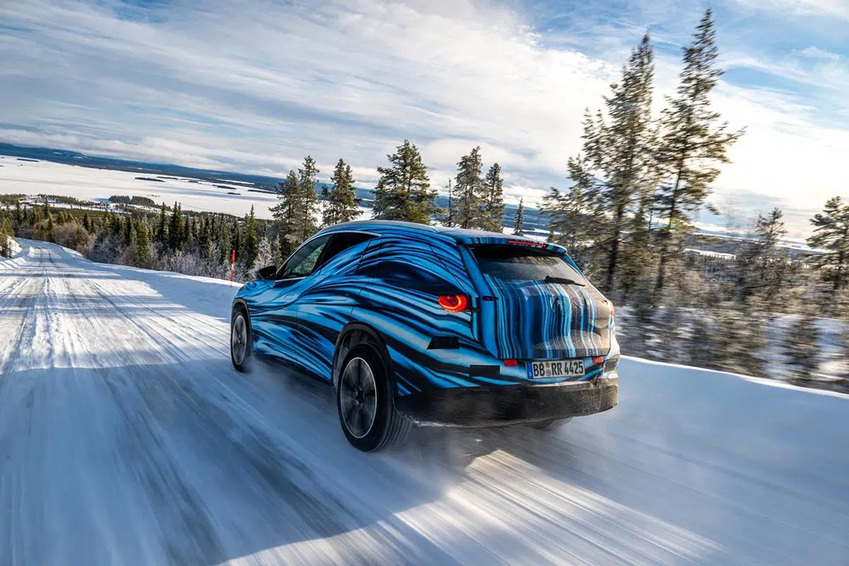 Vue arrière du Mercedes GLC électrique camouflé franchissant un terrain enneigé lors de tests hivernaux
