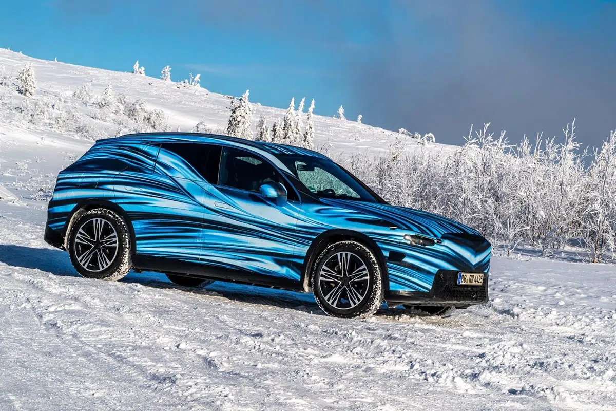 Prototype camouflé du Mercedes GLC électrique en test hivernal sur route enneigée, vu de profil